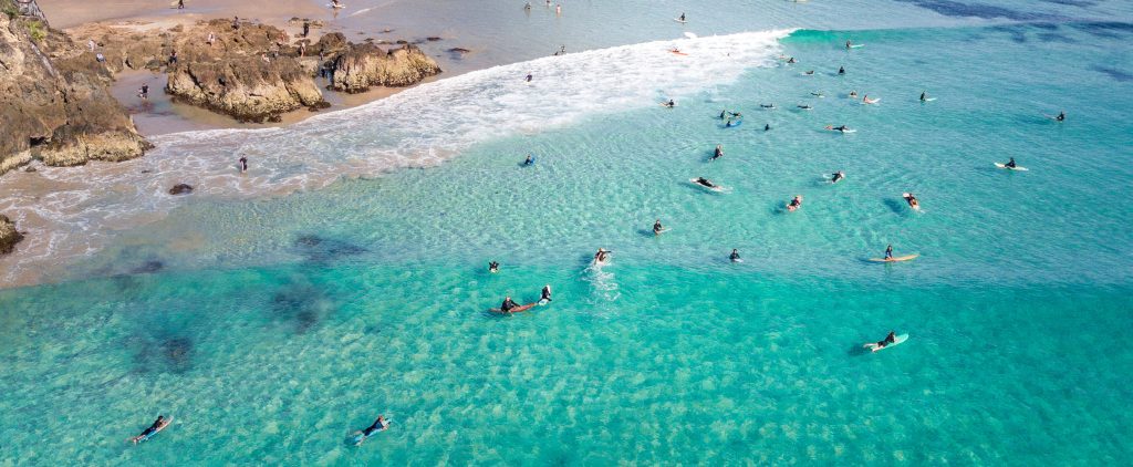 Aerial view of people swimming in clear turquoise water at Australian beach