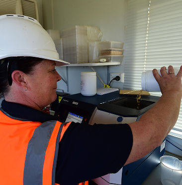 Worker inspecting or installing equipment indoors with safety helmet
