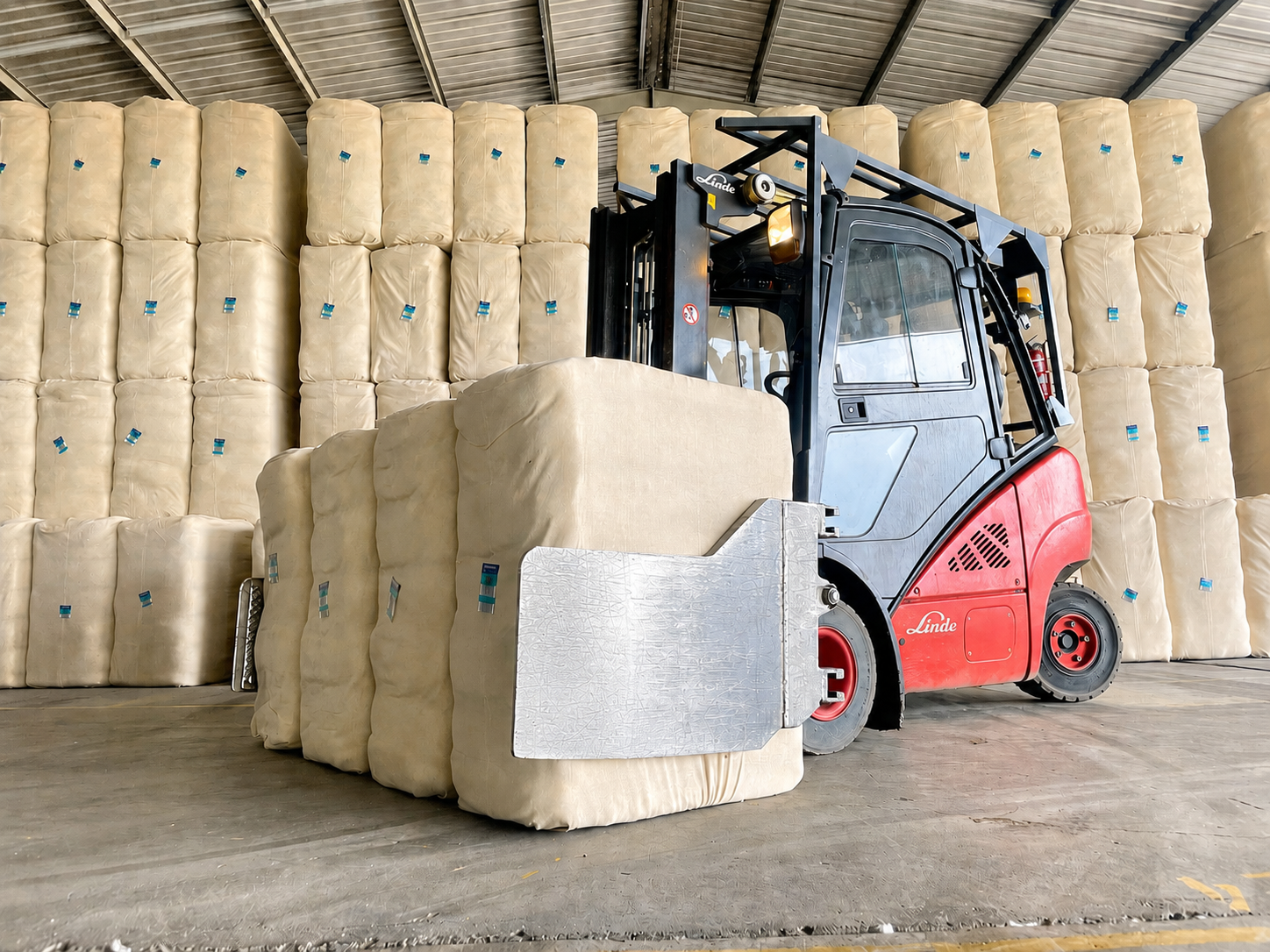 Forklift moving compressed bales in warehouse